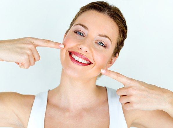 woman using both hands to point to smile