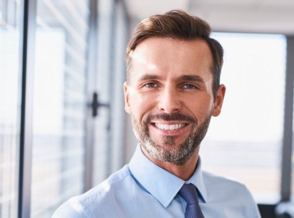 man in business attire smiling