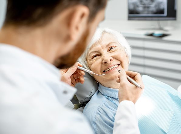 Senior patient smiling up at dentist
