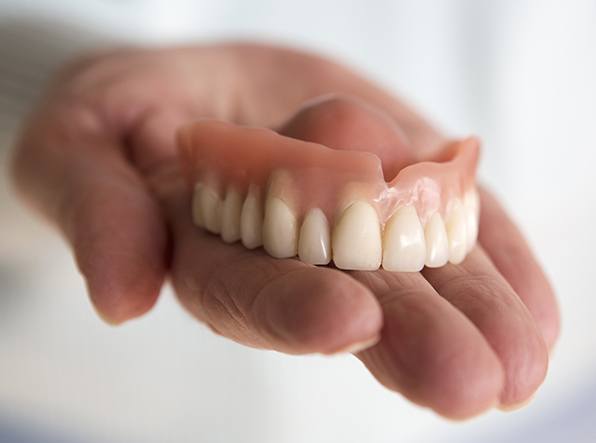 hand holding top denture