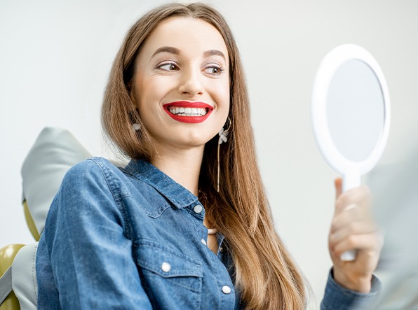 woman looking at smile in mirror