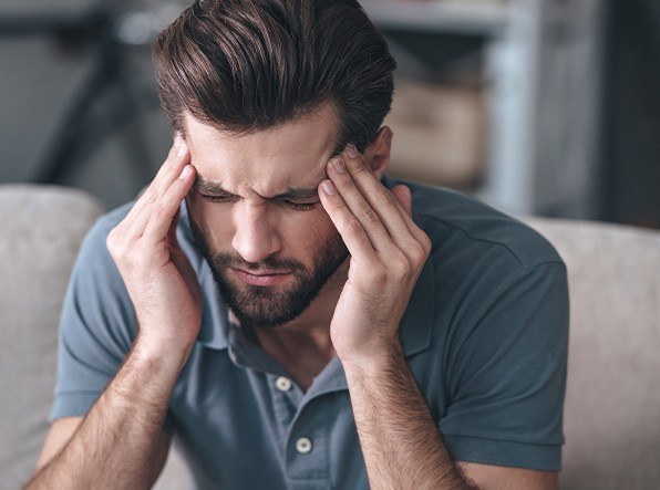 man holding head in pain